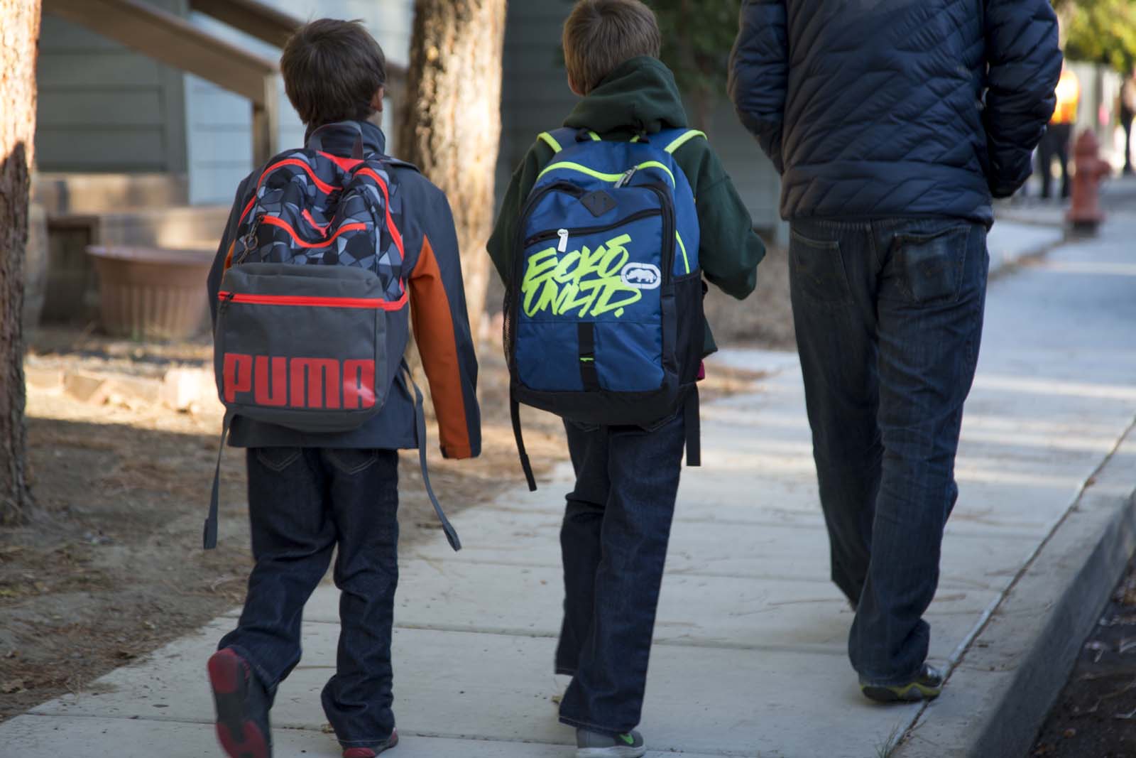 Kids with backpacks on sidewalk