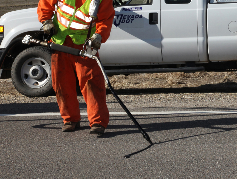 Person wearing orange working on a road